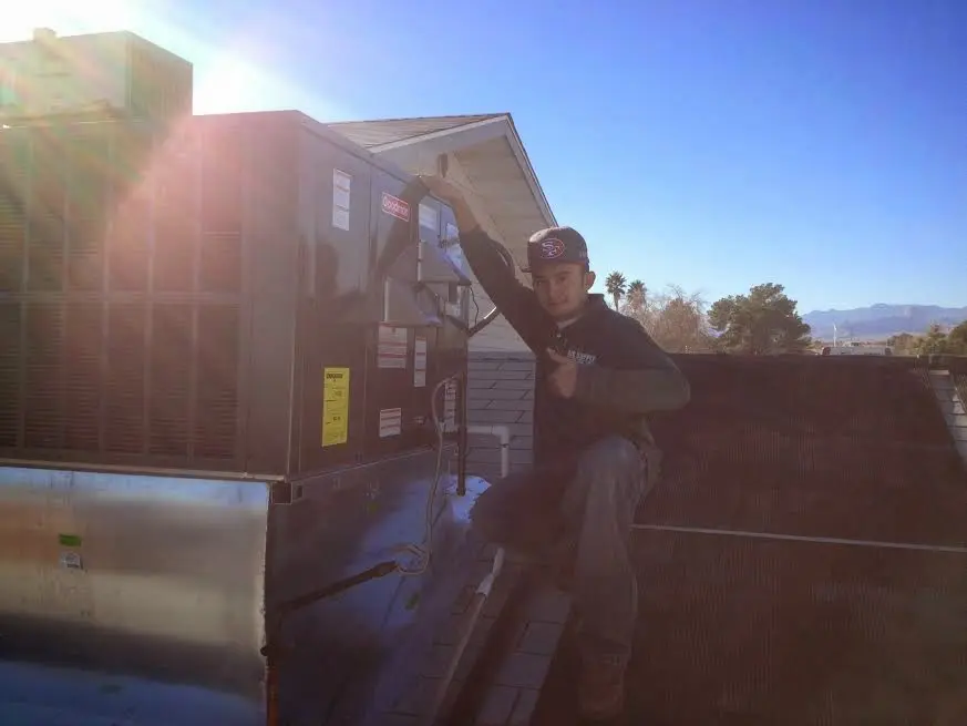 HVAC technician performing Boiler Repair on a rooftop unit in Dedham